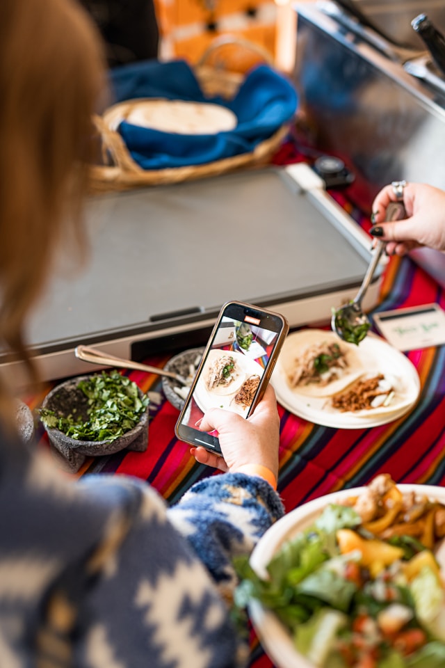 Cliente prenant une photo d'un plat dans une restaurant pour le partager sur Google